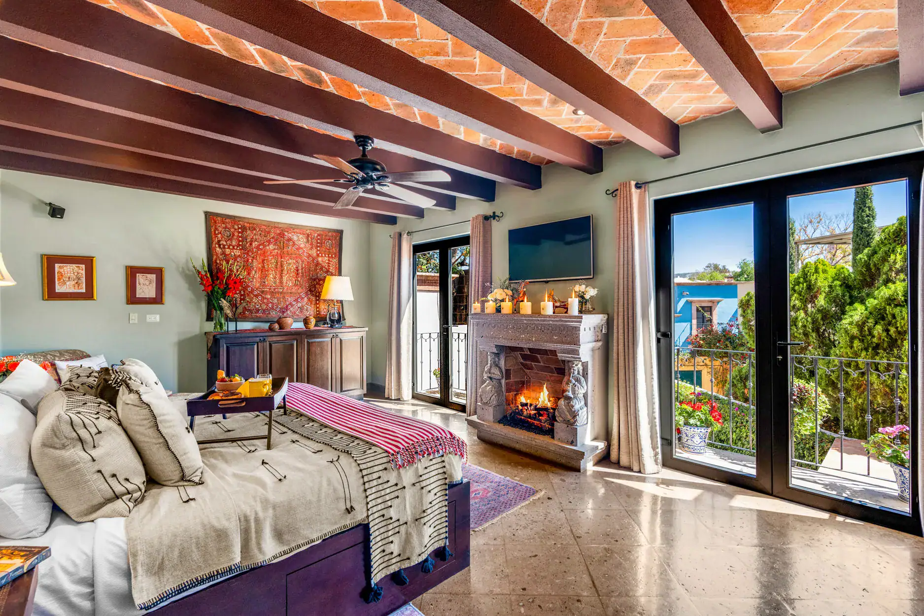 Casa Cleo Petra, bedroom with a fireplace and doors to a balcony, San Miguel de Allende