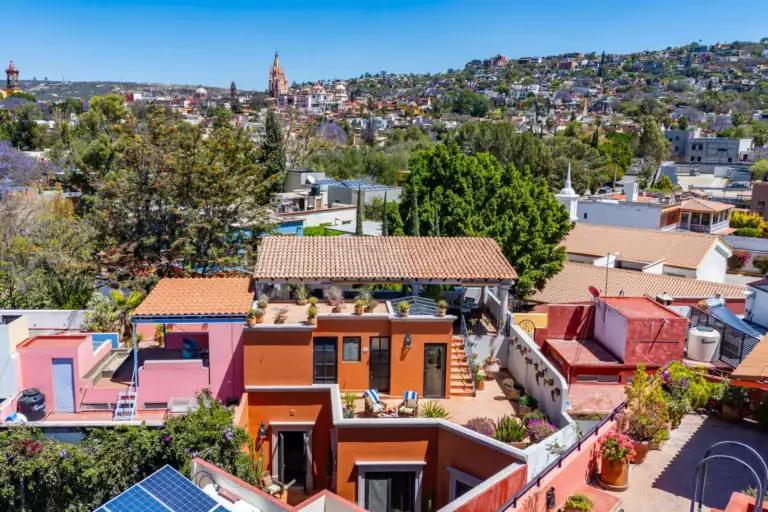 Casa Cleo Petra, aerial view of the house among the rooftops with the Parroquia behind, San Miguel de Allende