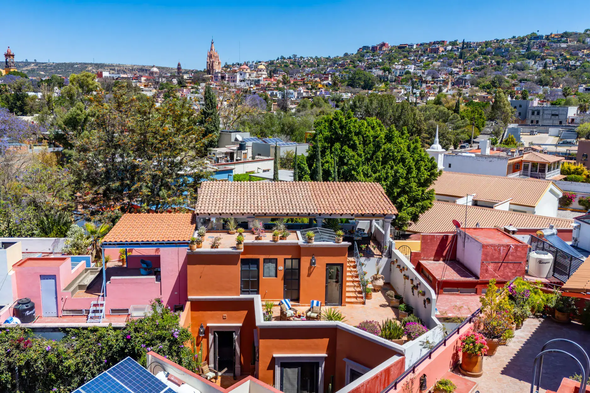 Casa Cleo Petra, aerial view of the house among the rooftops with the Parroquia behind, San Miguel de Allende
