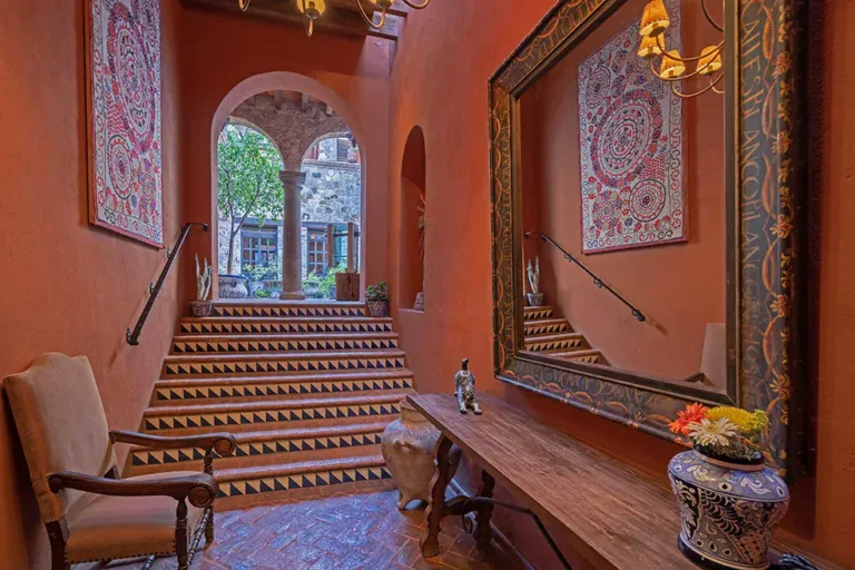 Casa Colonial, grand stair with tiled risers and a carved mirror in the orange hall, San Miguel de Allende