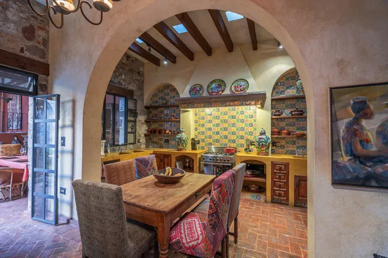 Casa Colonial, kitchen with talavera tile, open shelves and a wood dining table, San Miguel de Allende