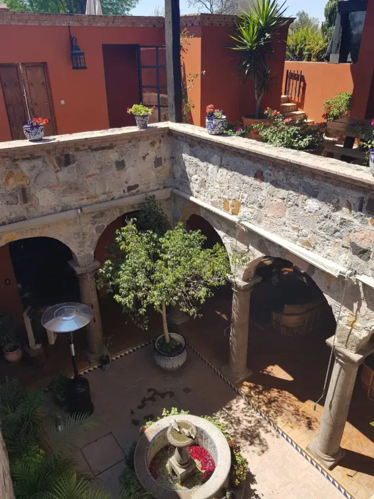 Casa Colonial, aerial view of the stone courtyard with a fountain and arches, San Miguel de Allende