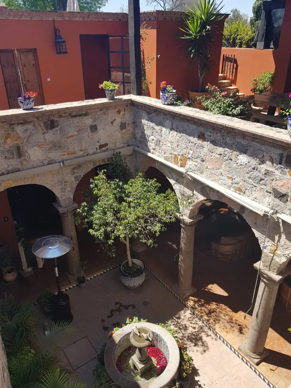 Casa Colonial, aerial view of the stone courtyard with a fountain and arches, San Miguel de Allende