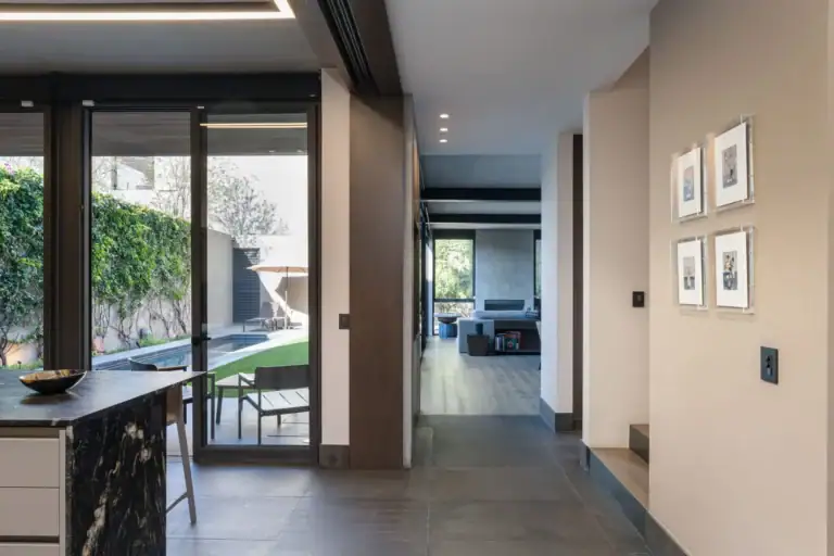 Casa Core, entry hallway with a glass door to the garden and framed prints on the wall, San Miguel de Allende