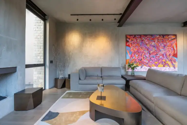 Casa Core, living room with a gray sectional, brass coffee table and a vivid pink painting, San Miguel de Allende