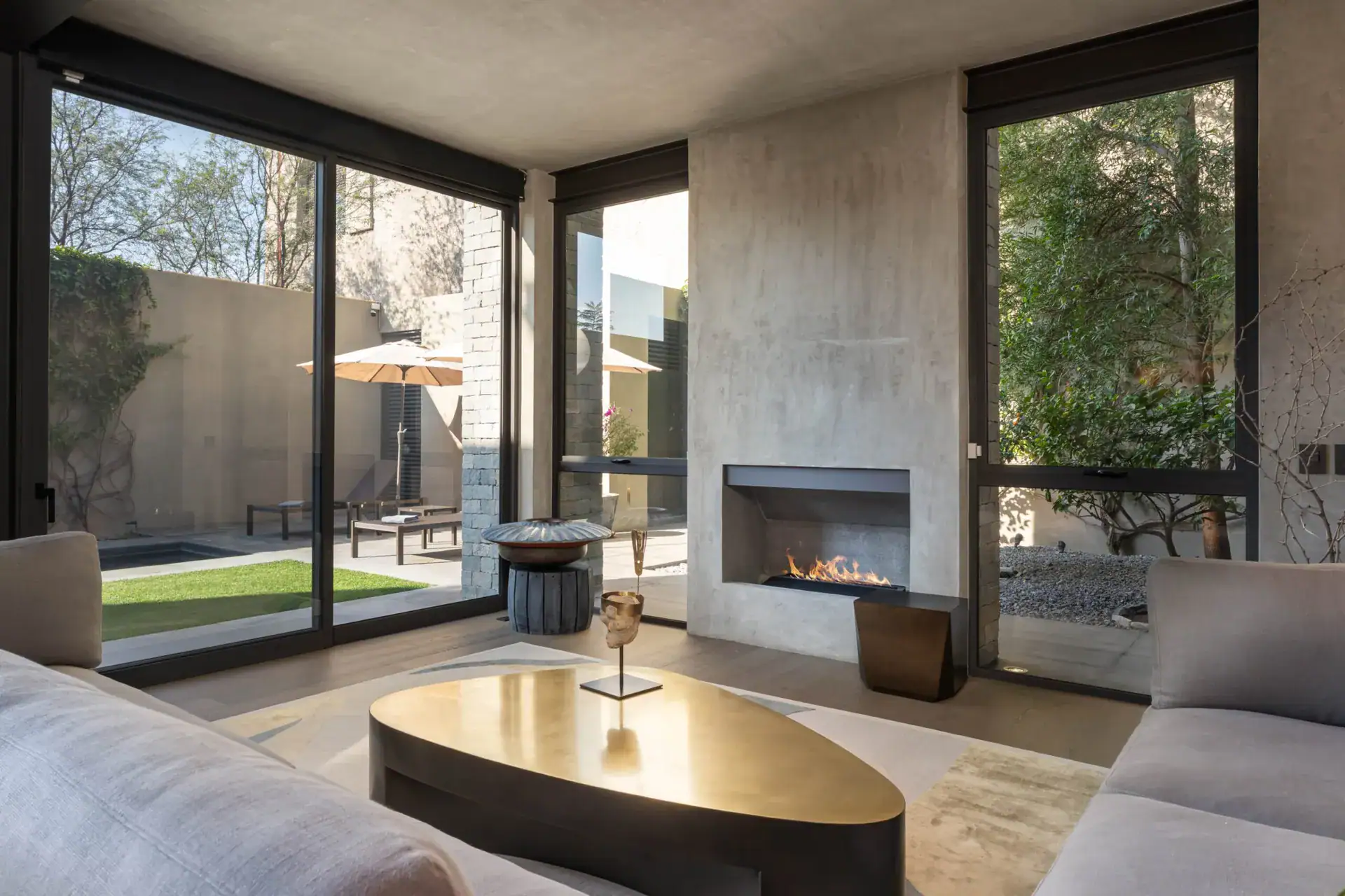 Casa Core, living room with a gas fireplace between tall windows facing the lawn, San Miguel de Allende