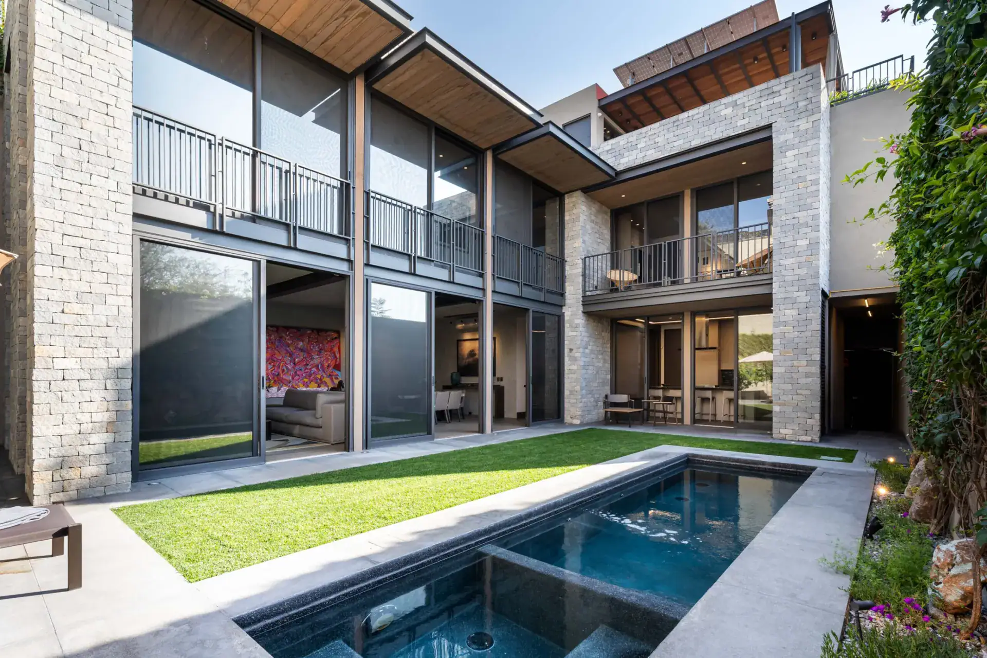 Casa Core, courtyard pool, lawn and the glass-walled facade of the house, San Miguel de Allende