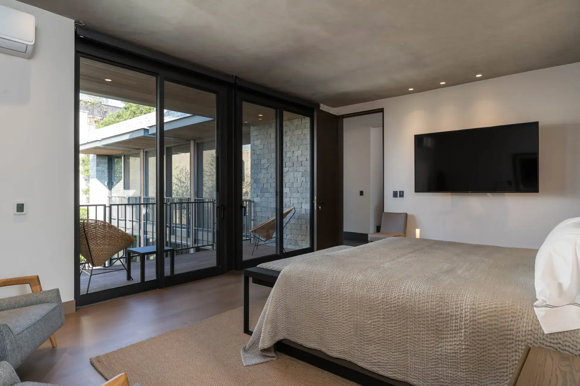 Casa Core, bedroom with a television and a view through sliding doors to a balcony, San Miguel de Allende