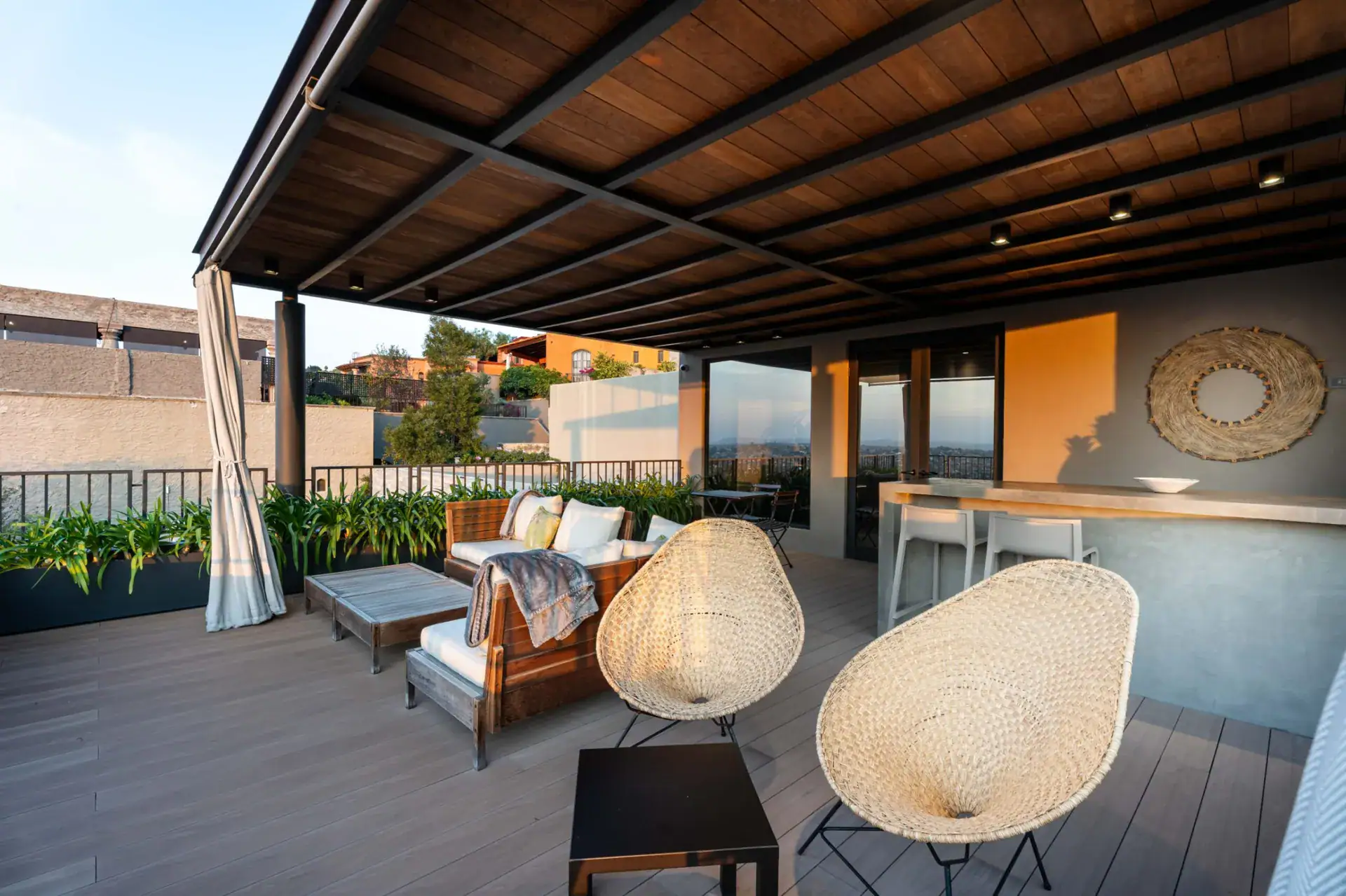 Casa Core, rooftop lounge with a wood ceiling, woven chairs and a bar counter, San Miguel de Allende