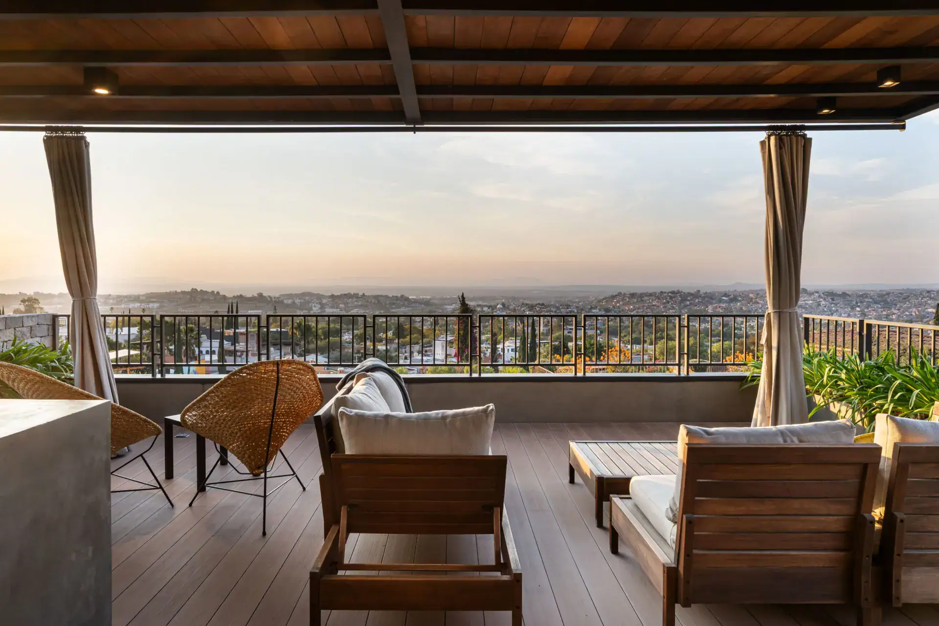 Casa Core, rooftop seating under a wood roof looking out at the hills at sunset, San Miguel de Allende