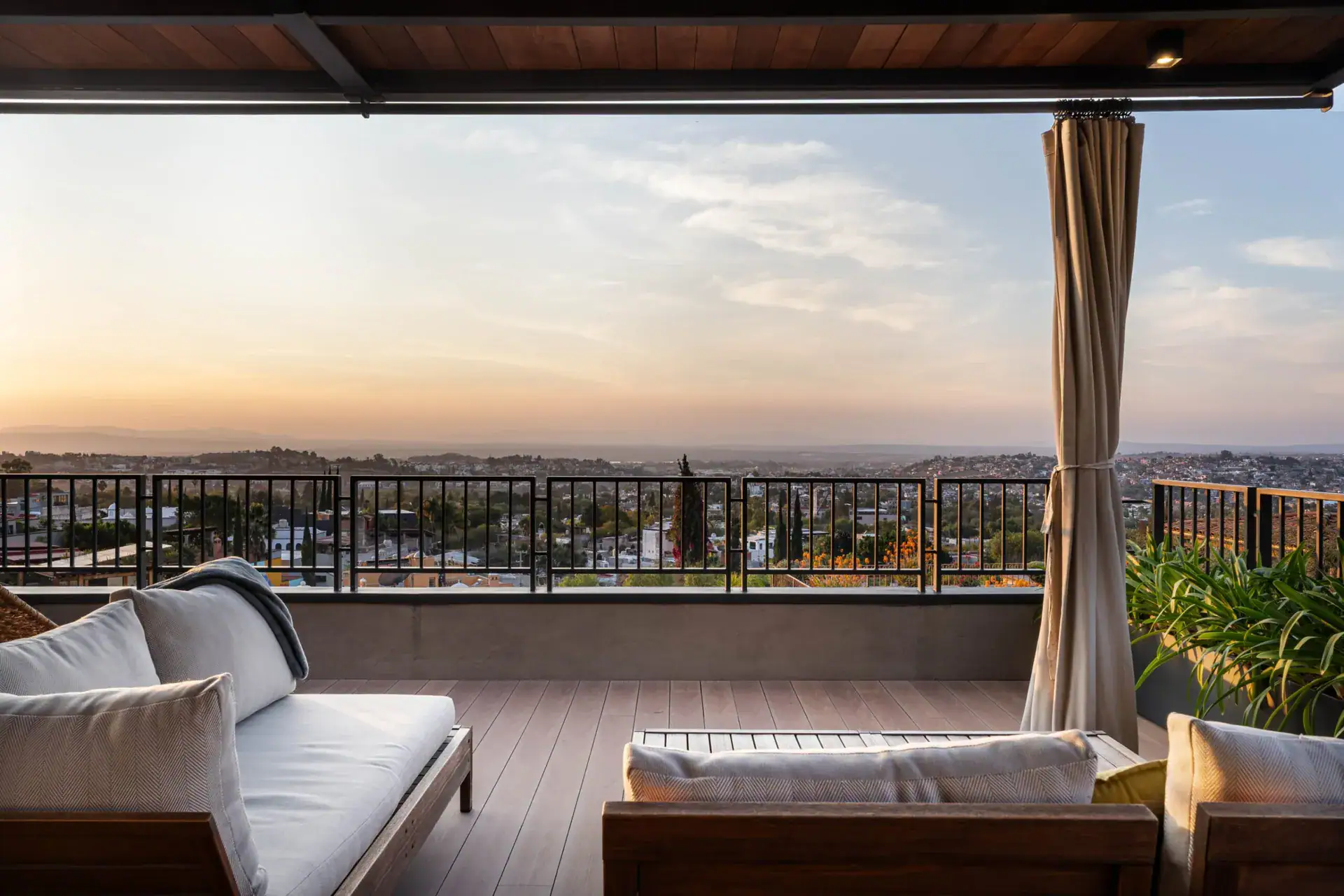 Casa Core, rooftop terrace with a sofa and the sky glowing at dusk, San Miguel de Allende