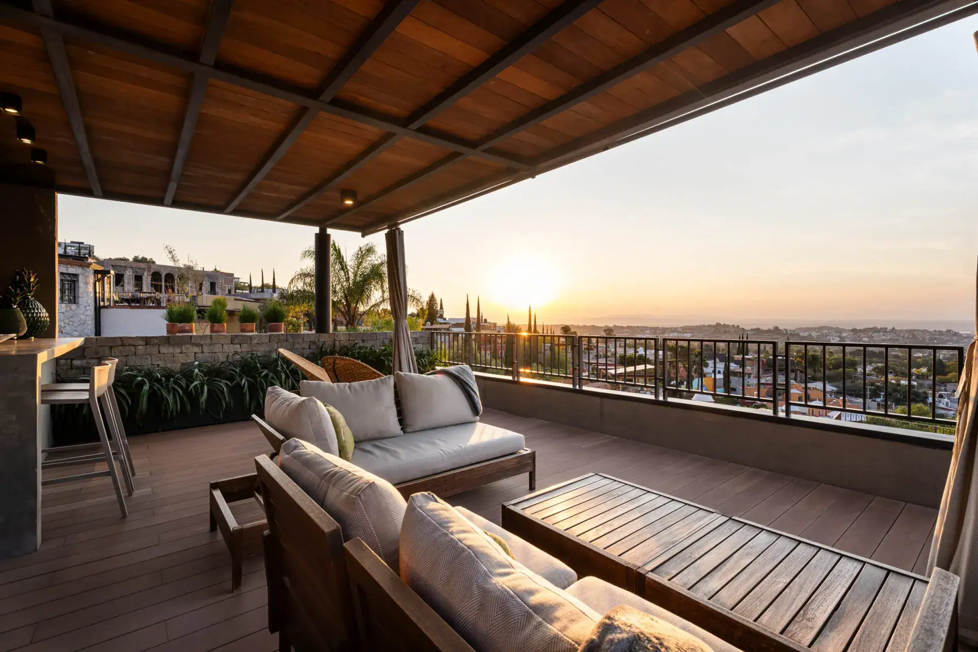 Casa Core, rooftop terrace at sunset with a bar and outdoor sofas, San Miguel de Allende