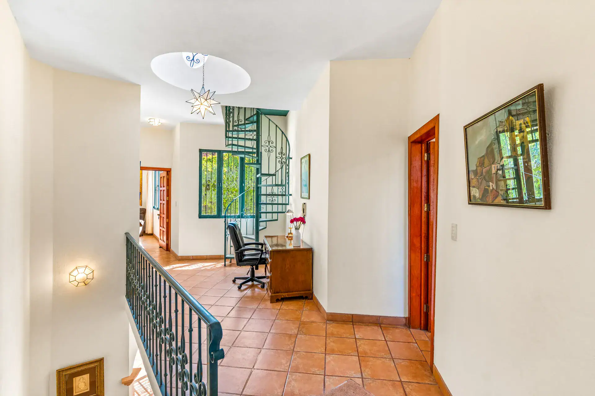 Casa Cul-De-Sac Armonia, upstairs landing with a spiral stair, a desk and chair, an octagonal skylight and an iron railing, San Miguel de Allende