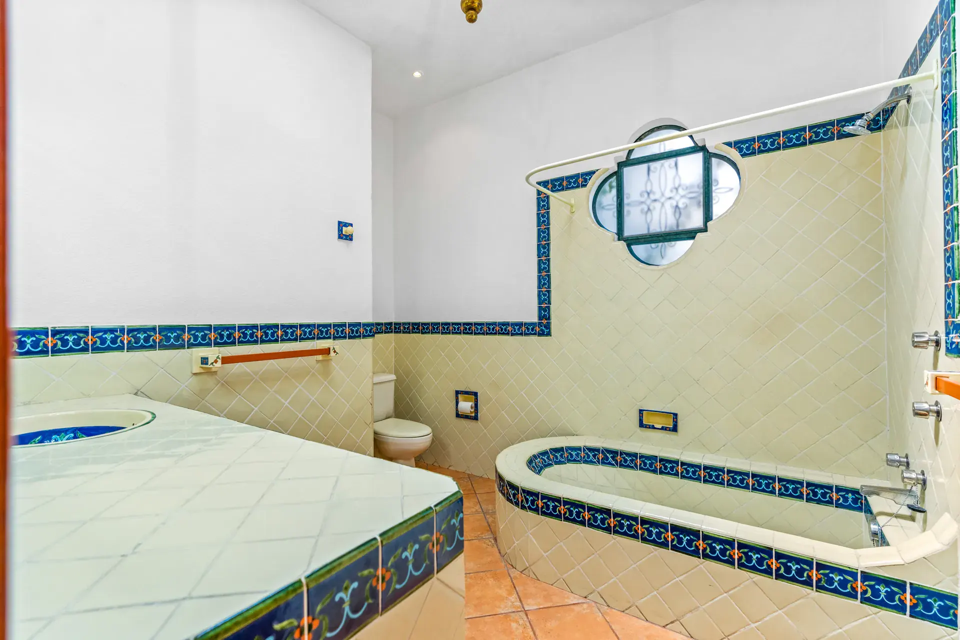 Casa Cul-De-Sac Armonia, bathroom with a tile tub, a decorated tile vanity and a quatrefoil window, San Miguel de Allende