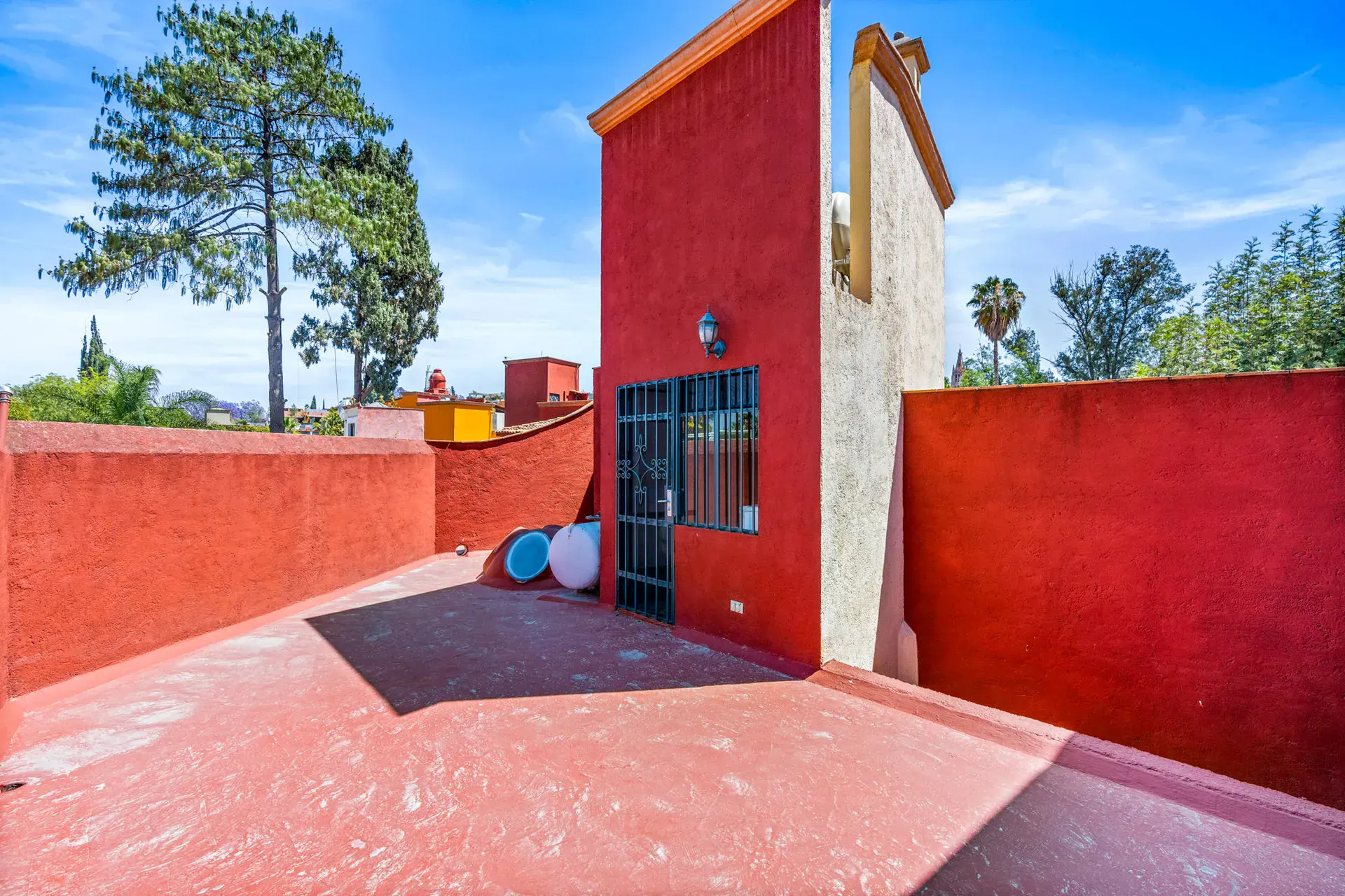 Casa Cul-De-Sac Armonia, red-walled roof terrace with a tower, a pine tree and views of the neighborhood, San Miguel de Allende