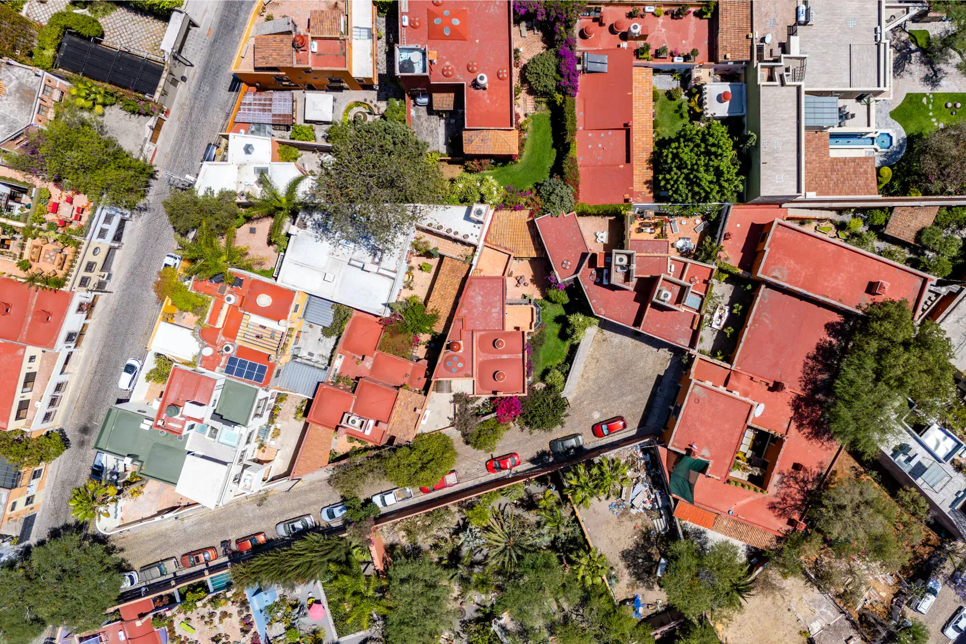 Casa Cul-De-Sac Armonia, aerial view of the red house and surrounding rooftops of the neighborhood, San Miguel de Allende