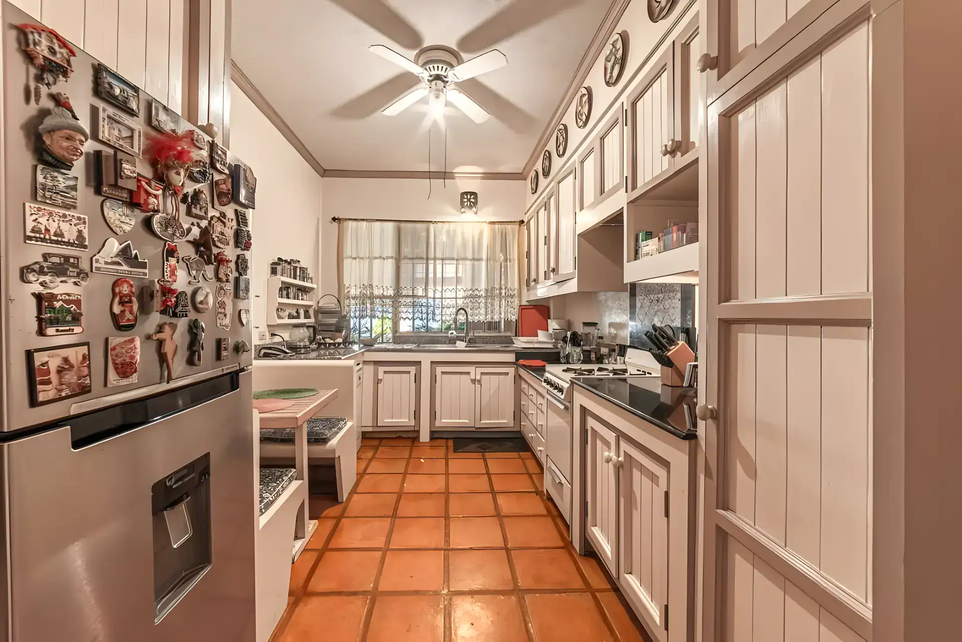Casa de la Gracia, kitchen with cream cabinets, a stainless refrigerator covered in magnets and a breakfast nook, San Miguel de Allende