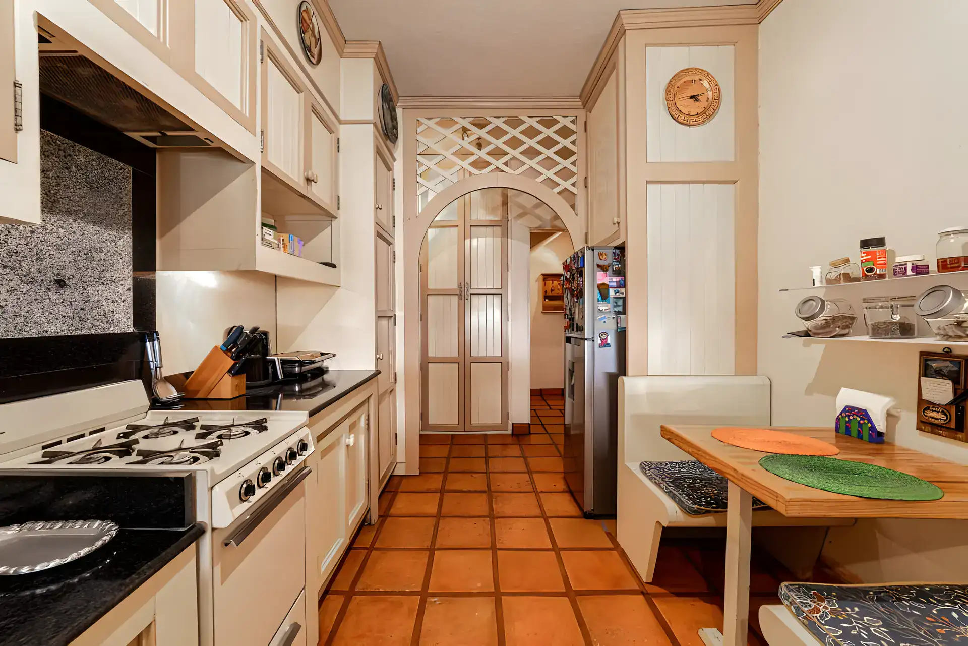 Casa de la Gracia, galley kitchen with a gas range, black granite counters and a breakfast table with bench seating, San Miguel de Allende