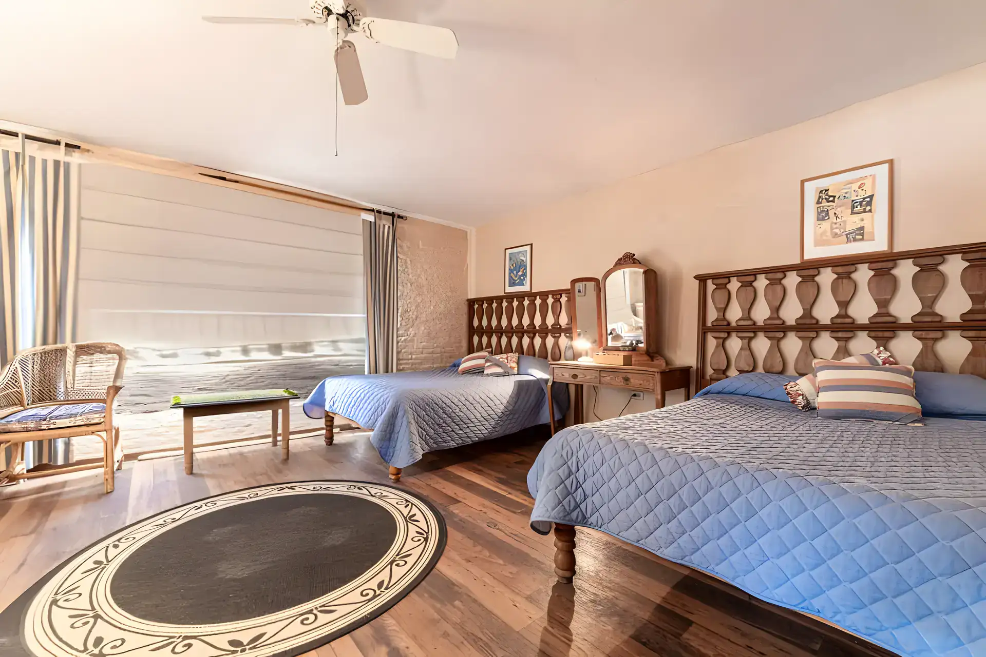 Casa de la Gracia, bedroom with a king bed, a twin bed, blue quilts and a round rug, San Miguel de Allende