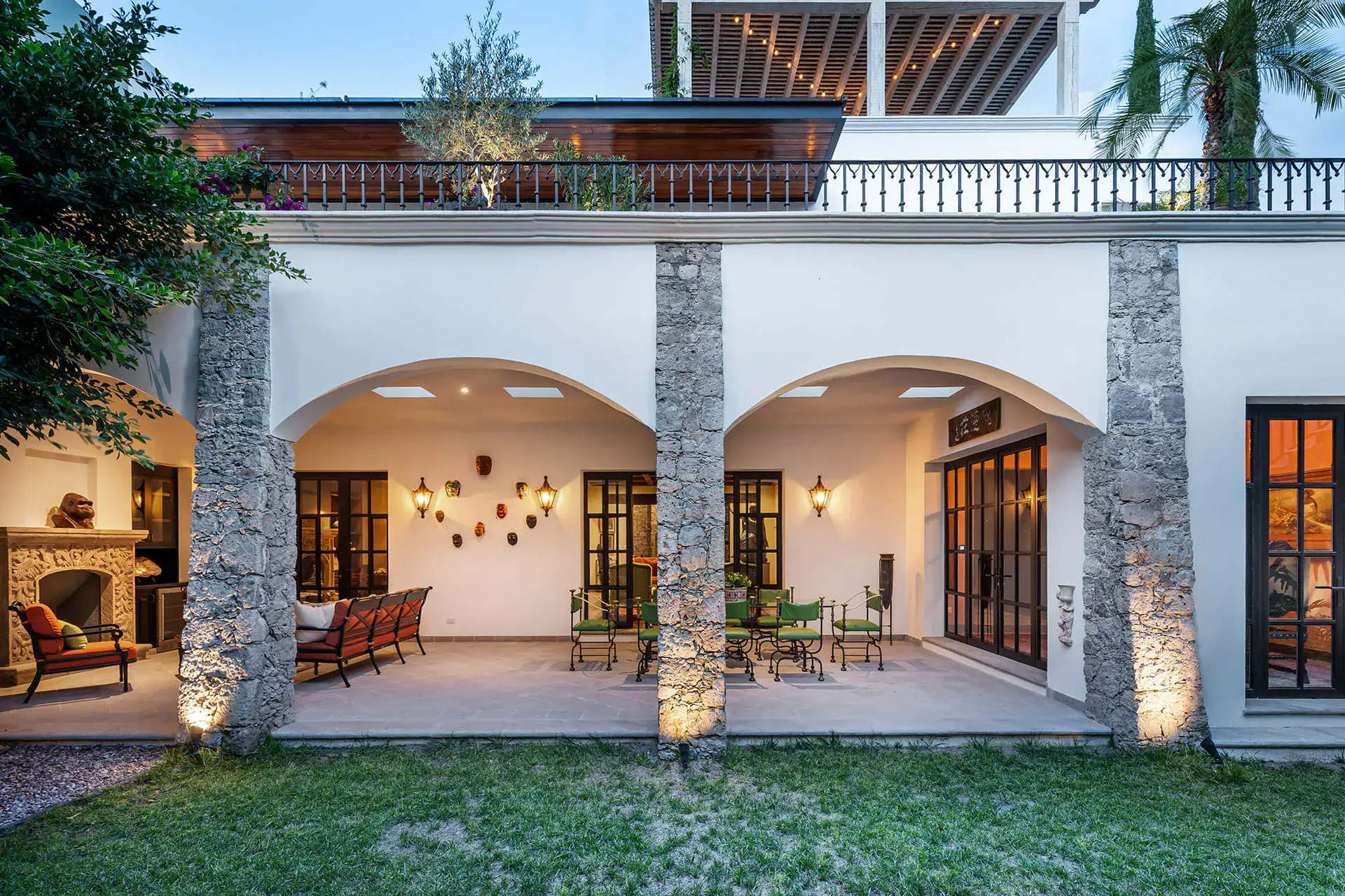Casa de la Leona, white arcaded loggia facing a lawn, lit at dusk, San Miguel de Allende