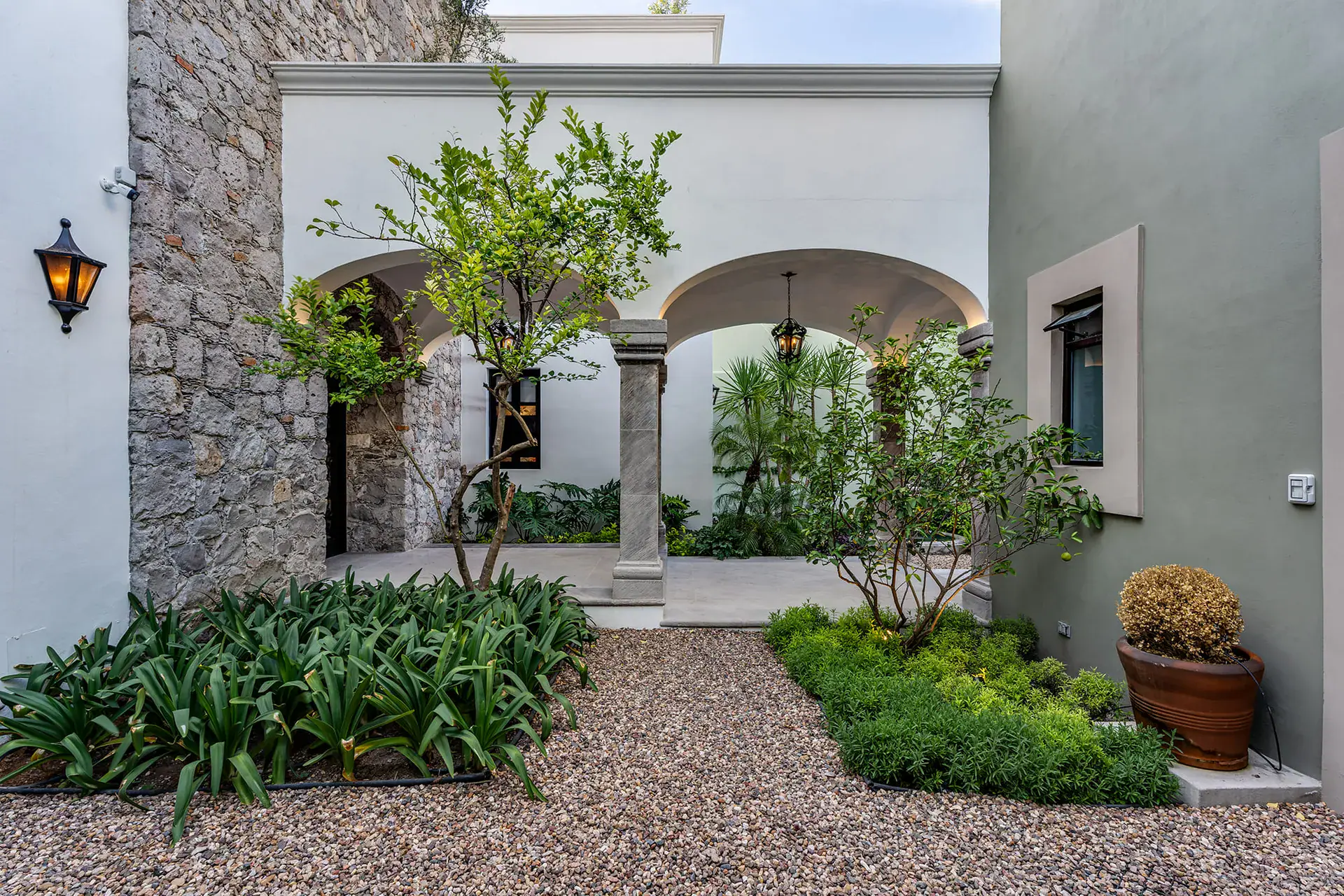 Casa de la Leona, stone and stucco courtyard with arches, citrus trees and a gravel garden, San Miguel de Allende