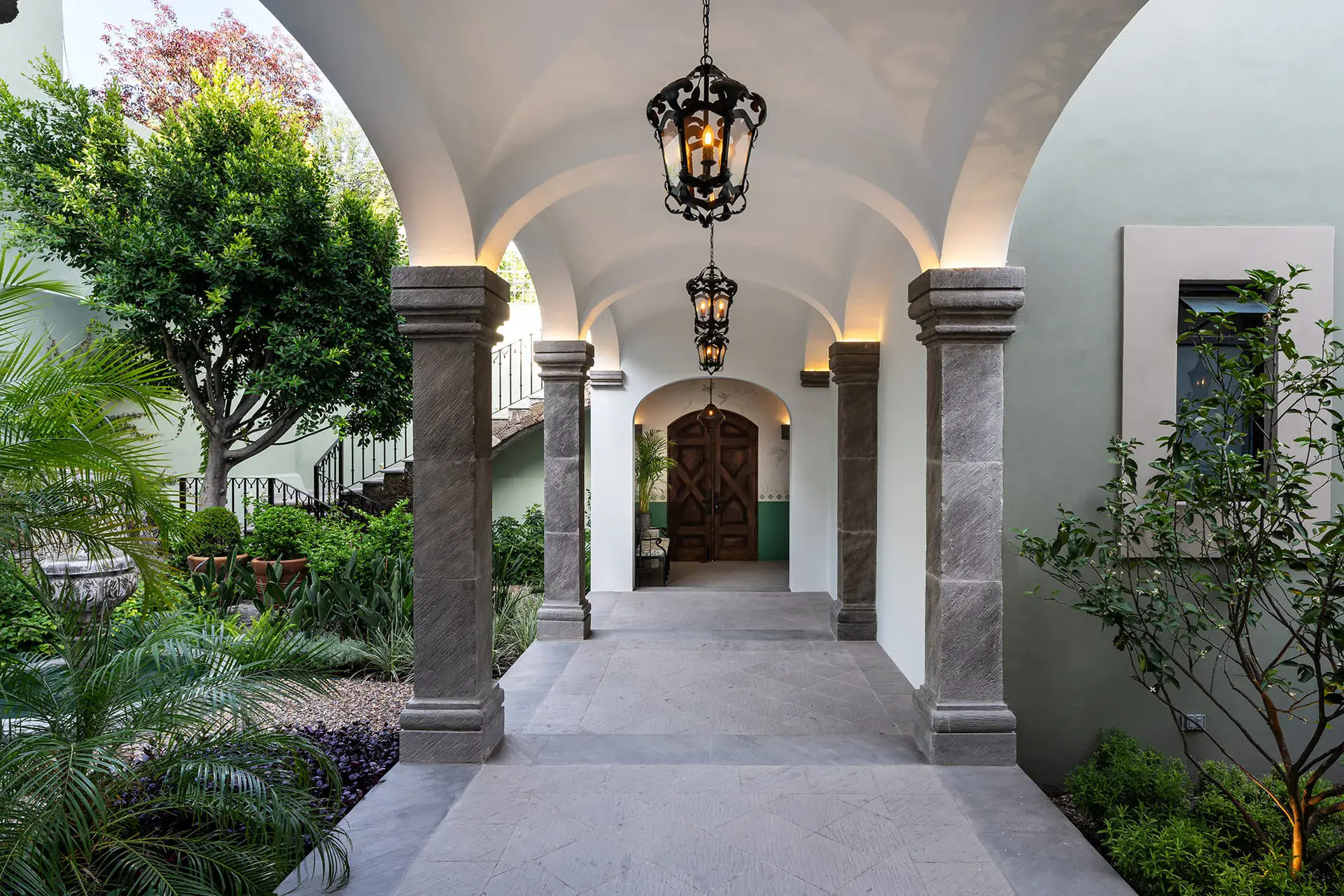 Casa de la Leona, vaulted stone colonnade leading to an arched wood door, San Miguel de Allende