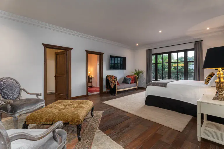 Casa de la Leona, primary bedroom with a sitting area and large windows, San Miguel de Allende
