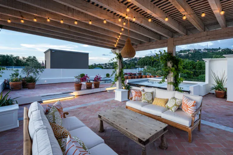 Casa de la Leona, rooftop terrace with sofas under a wood pergola and string lights, San Miguel de Allende