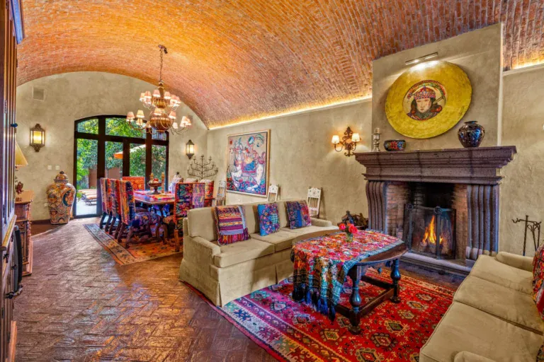 Casa de la Suerte, living room with a stone fireplace, a brick vaulted ceiling and colorful textiles, San Miguel de Allende