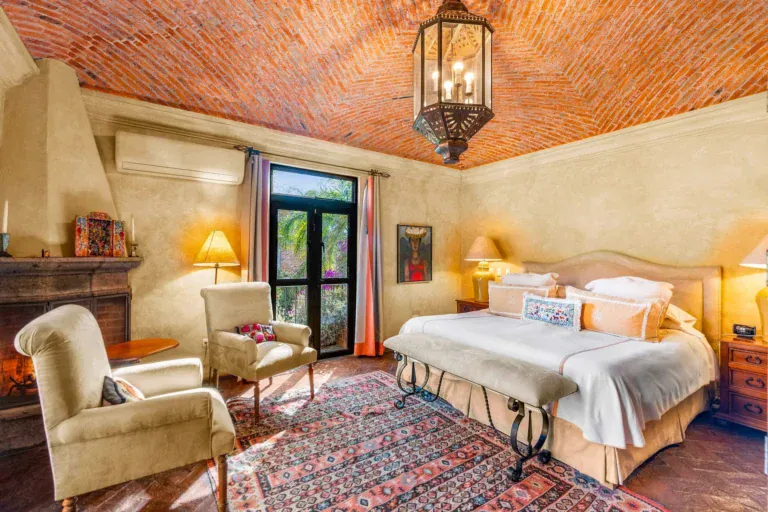 Casa de la Suerte, primary bedroom with a brick ceiling, a fireplace and a sitting area, San Miguel de Allende