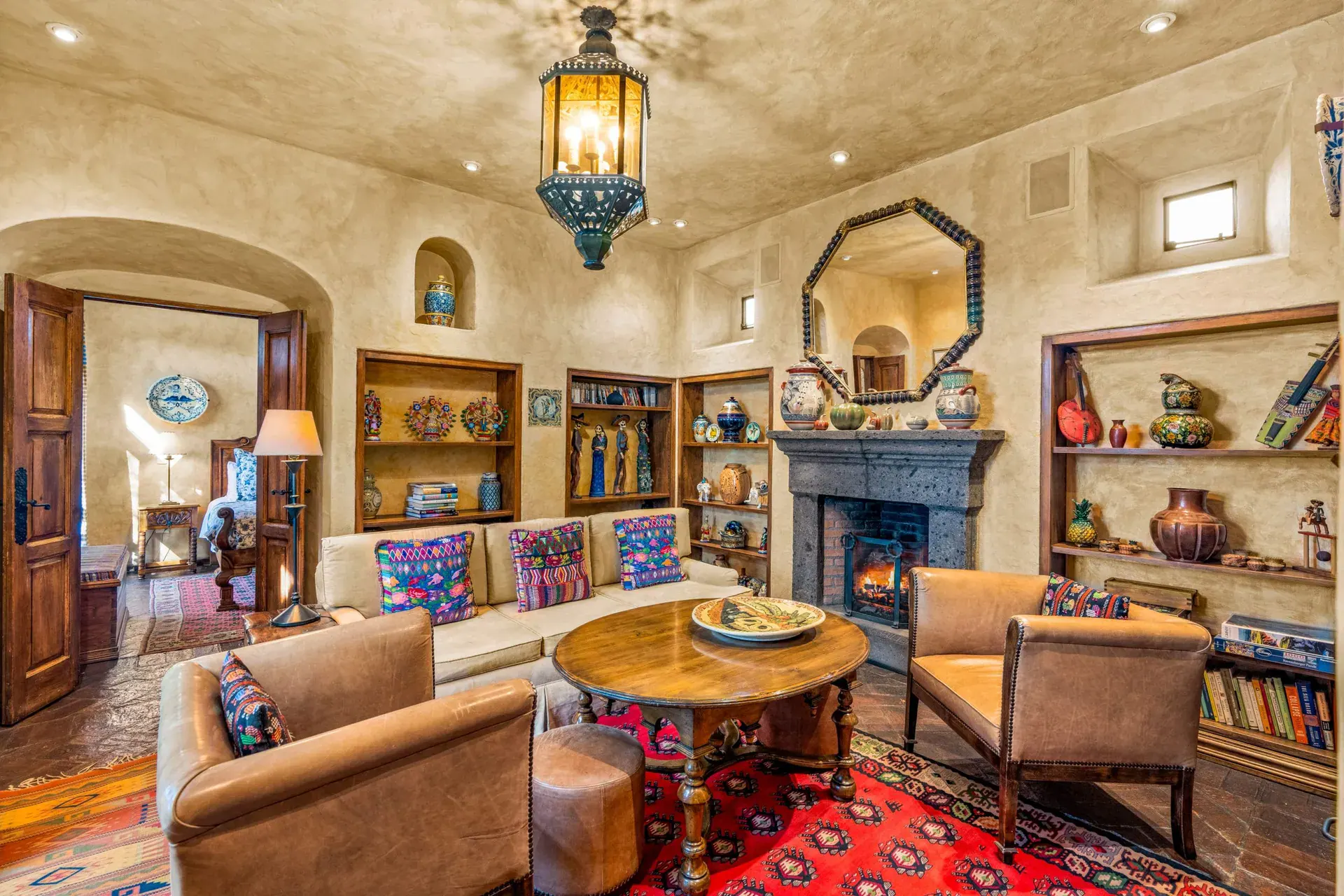 Casa de la Suerte, den with a fireplace, built-in shelves and leather armchairs, San Miguel de Allende