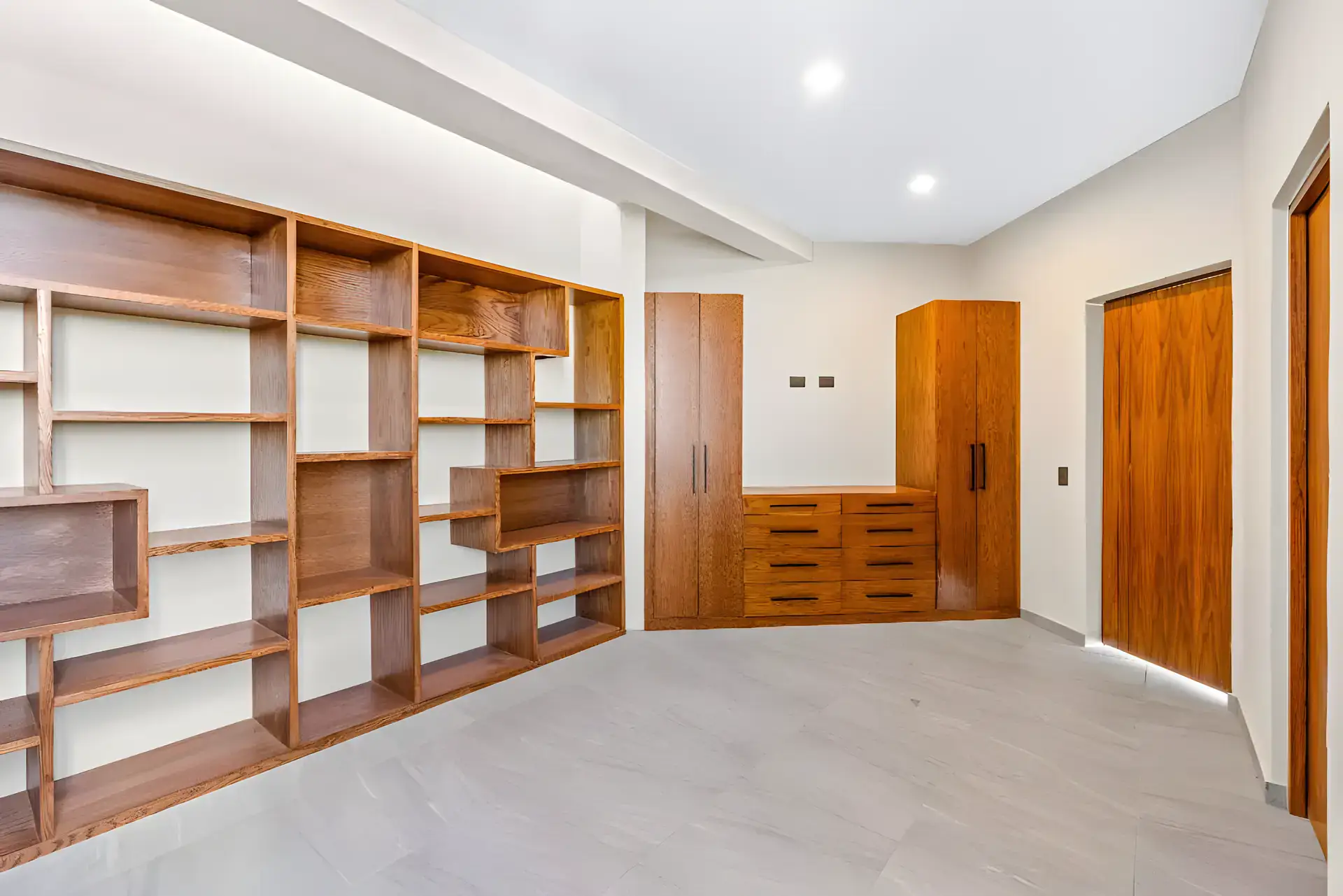 Casa de la Vista, empty room with wall-to-wall wood shelving, a wardrobe and a wood door, San Miguel de Allende