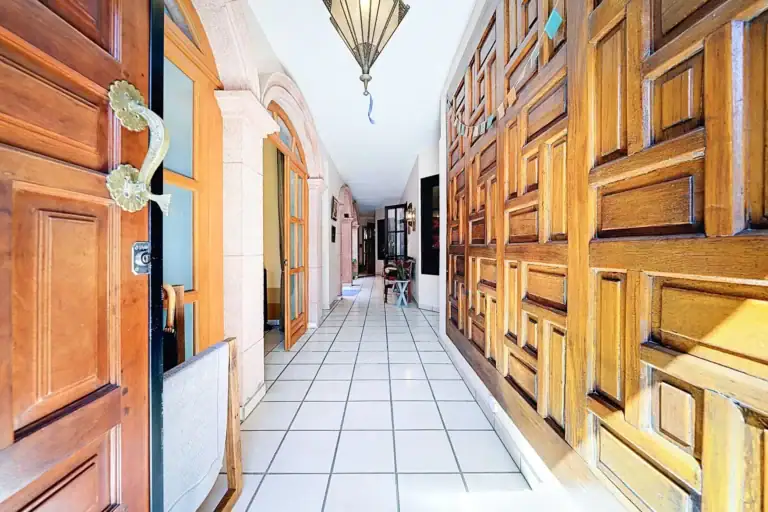 Casa de las Cruces, entry hallway with carved paneled wooden doors and a hanging lantern, San Miguel de Allende