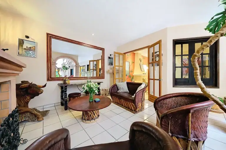 Casa de las Cruces, living room with equipale leather chairs, a carved wood bull and a large mirror, San Miguel de Allende