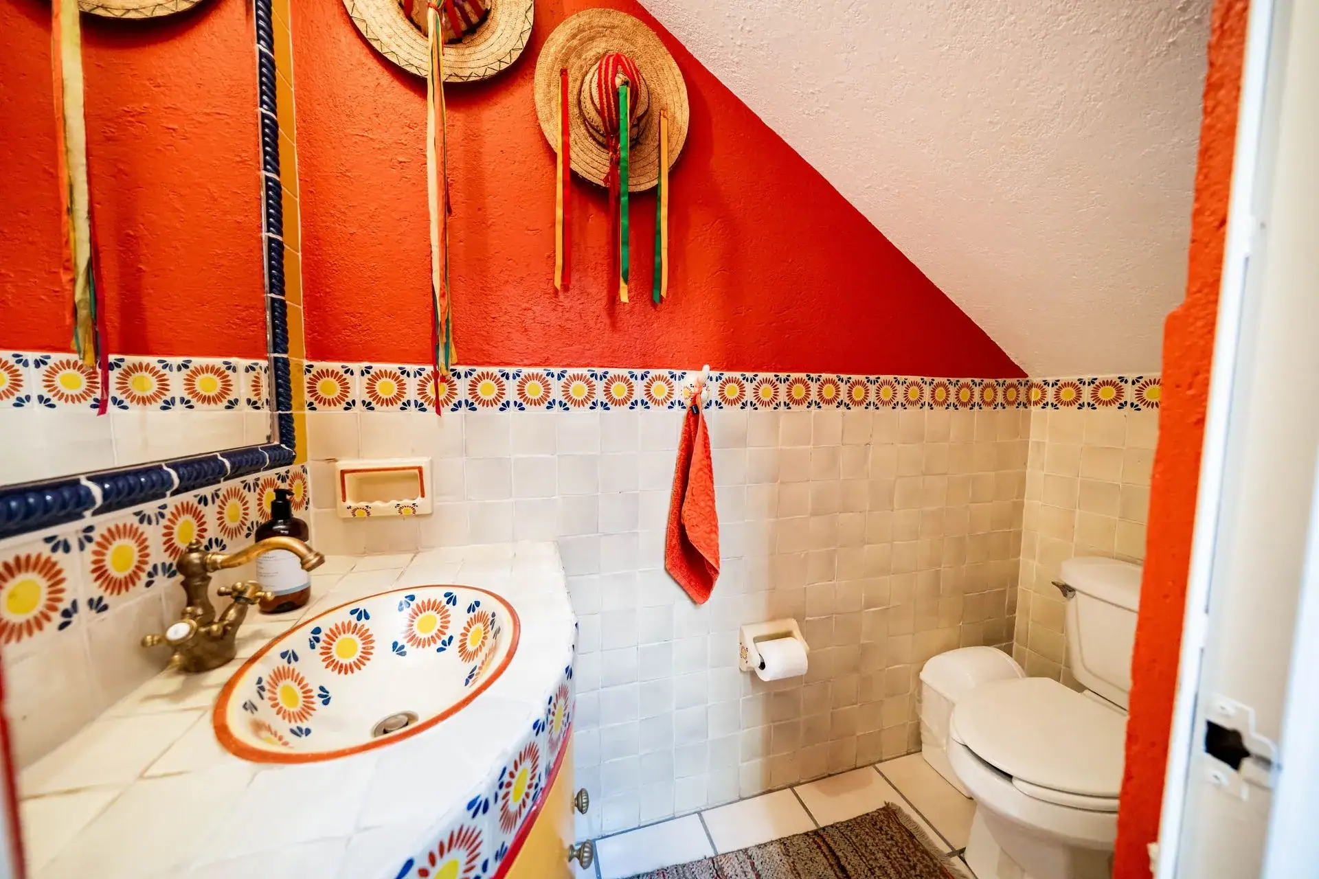 Casa de las Cruces, bathroom with a red wall, a hand-painted sink and a Talavera tile border, San Miguel de Allende