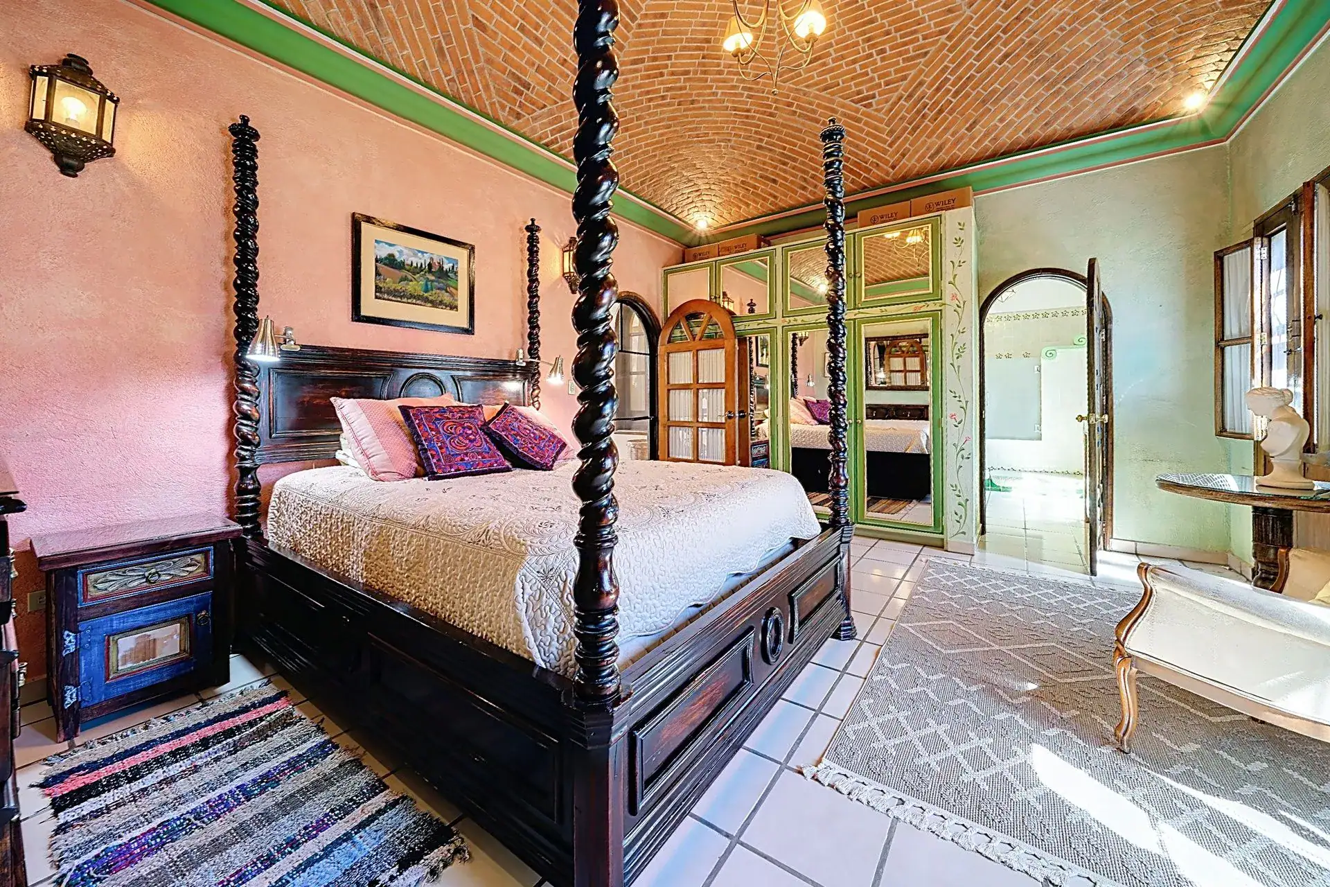 Casa de las Cruces, bedroom with a carved four-poster bed, brick vaulted ceiling and green-painted walls, San Miguel de Allende
