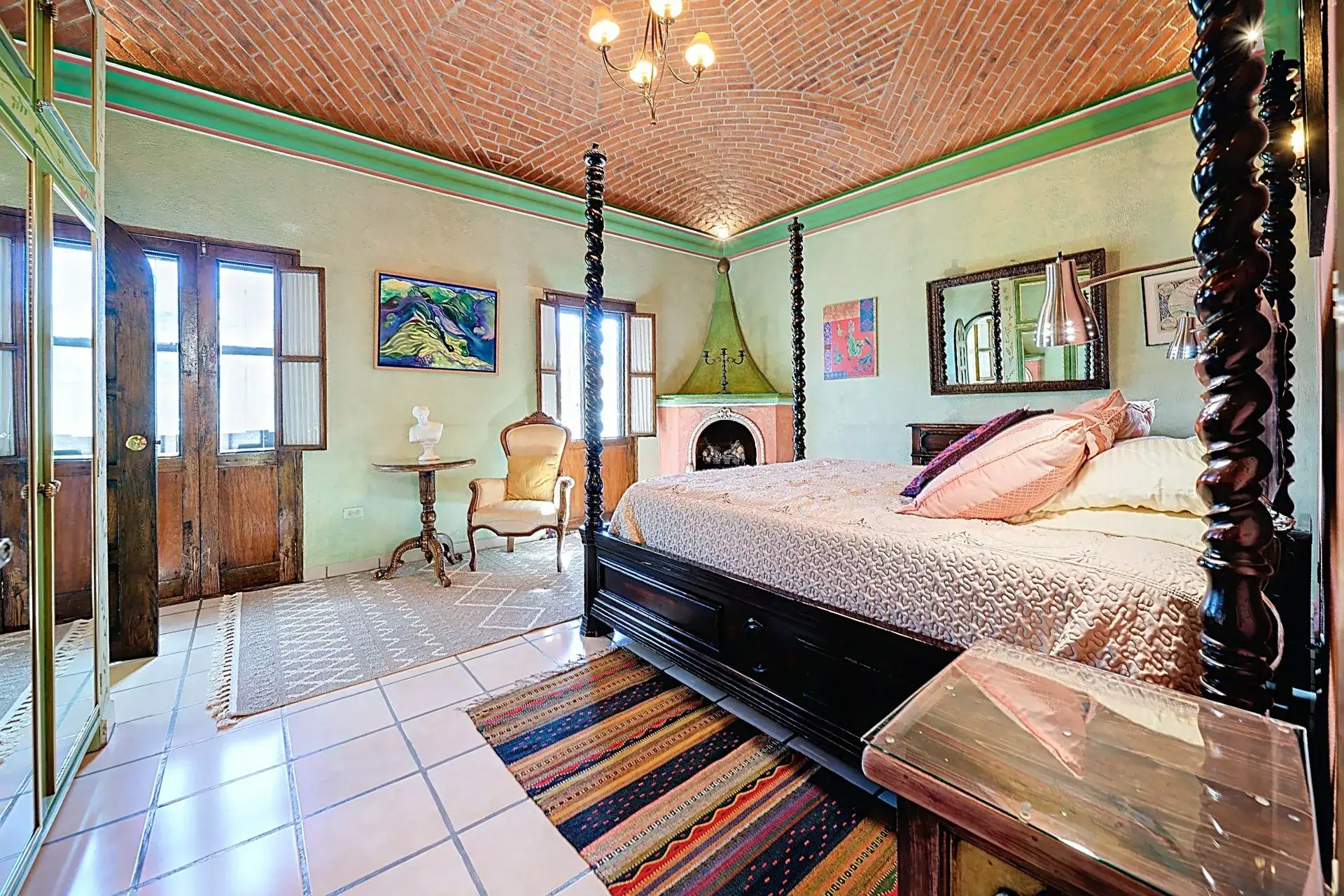 Casa de las Cruces, bedroom with a four-poster bed, a small corner fireplace and double doors, San Miguel de Allende