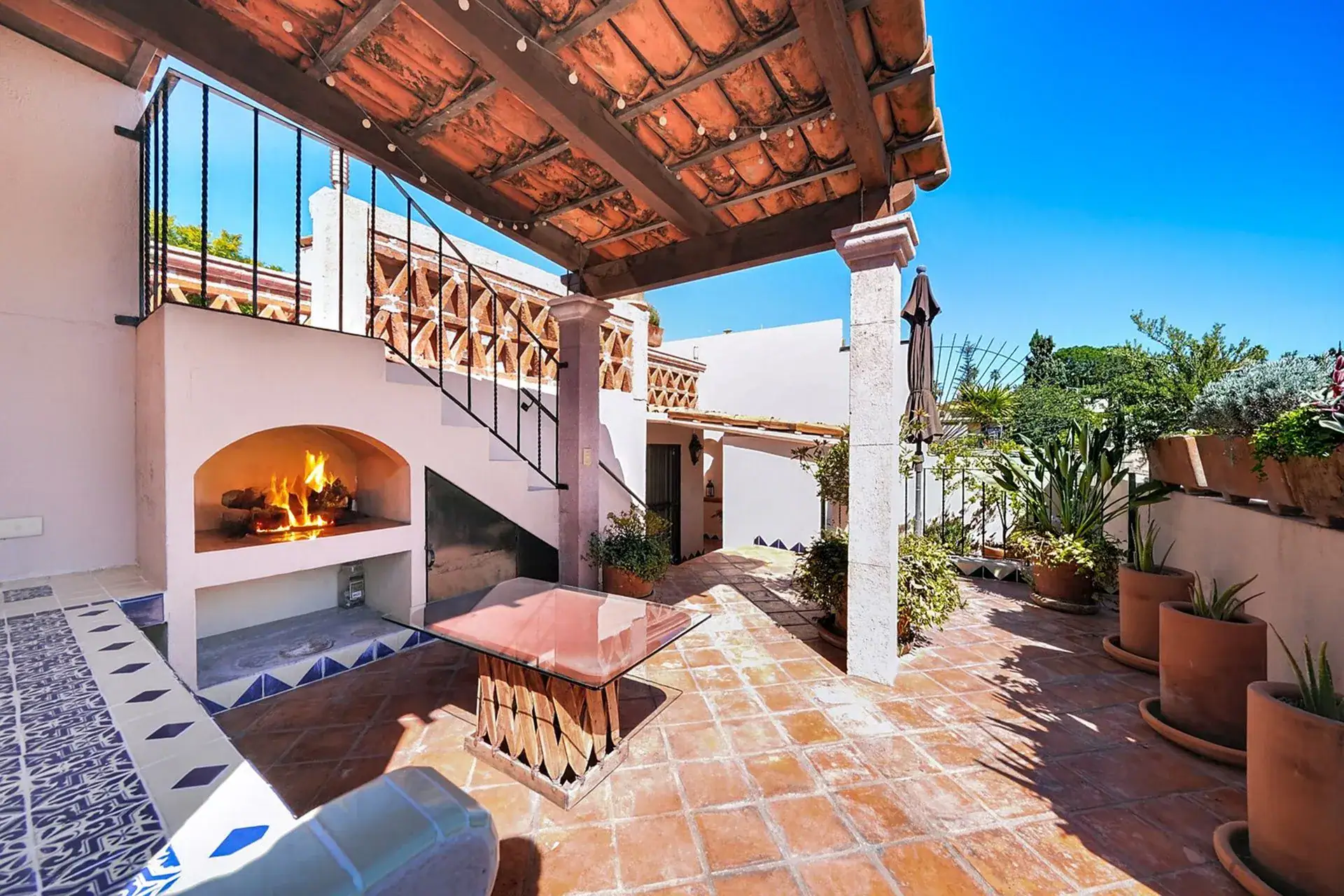 Casa de las Cruces, terrace with a built-in fireplace, a covered pergola and a tiled step, San Miguel de Allende