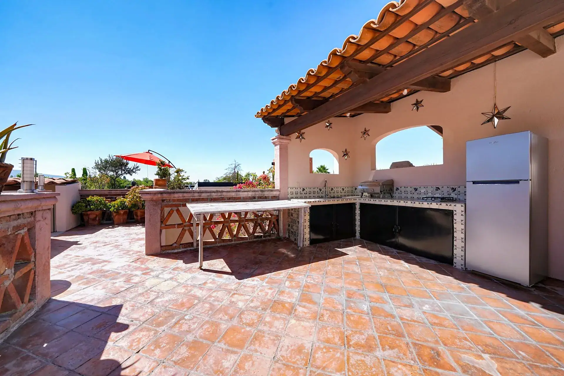 Casa de las Cruces, rooftop kitchen with a built-in grill and a refrigerator under a tile-roofed pavilion, San Miguel de Allende