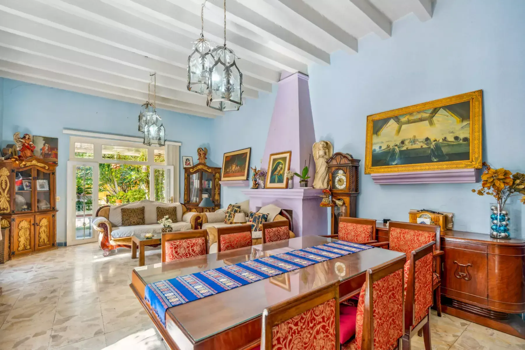 Casa de los Espejos, living room with a pink fireplace and a long dining table, San Miguel de Allende
