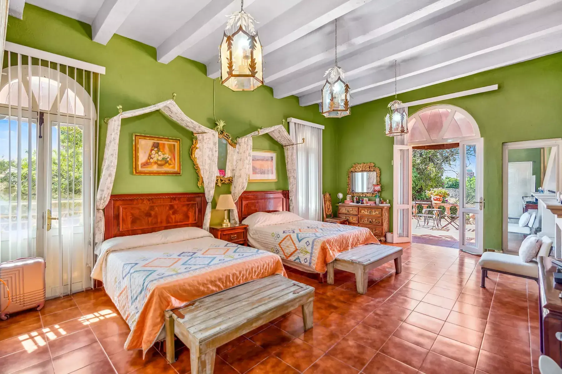 Casa de los Espejos, bedroom with a canopy bed, green walls and arched doors, San Miguel de Allende