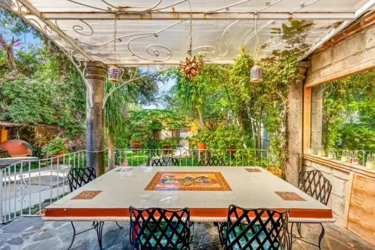 Casa de los Espejos, pergola dining table in a lush garden, San Miguel de Allende
