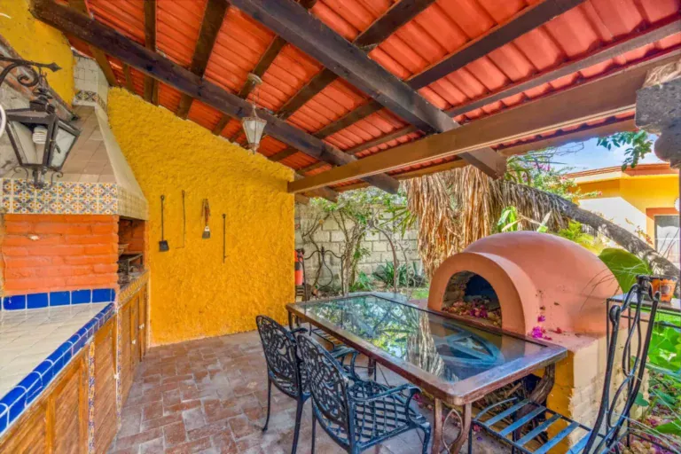Casa de los Espejos, covered outdoor kitchen with a pizza oven and a dining table, San Miguel de Allende
