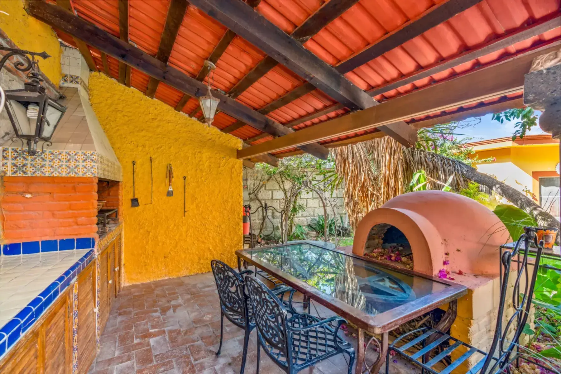Casa de los Espejos, covered outdoor kitchen with a pizza oven and a dining table, San Miguel de Allende