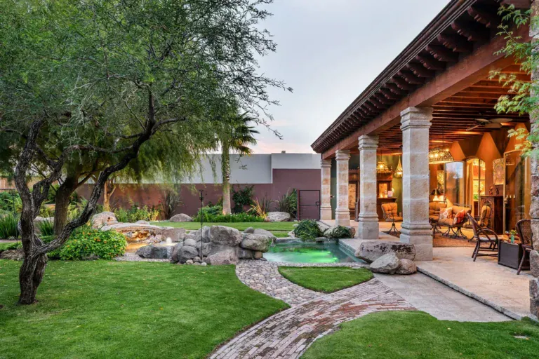 Casa de Salca, covered loggia beside a lawn and a rock pond at dusk, San Miguel de Allende
