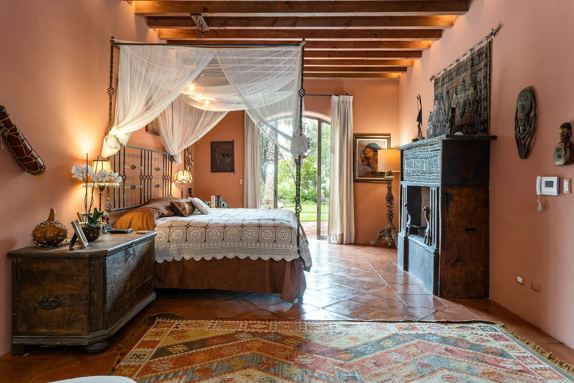 Casa de Salca, primary bedroom with a canopy bed and a carved chest, San Miguel de Allende