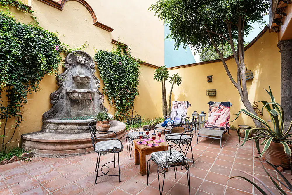 Casa DeeDee, patio with a tiered wall fountain and lounge chairs, San Miguel de Allende