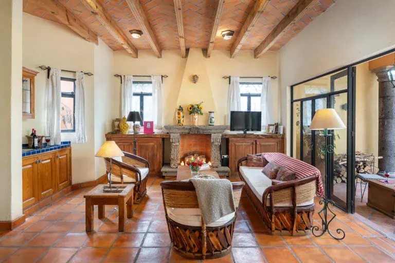 Casa DeeDee, living room with a stone fireplace, wood beams and a brick vaulted ceiling, San Miguel de Allende