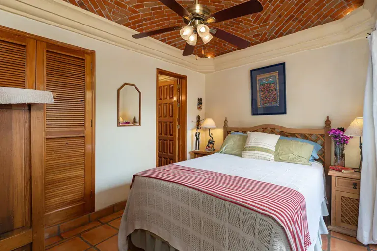 Casa DeeDee, bedroom with a brick vaulted ceiling and a red striped blanket, San Miguel de Allende