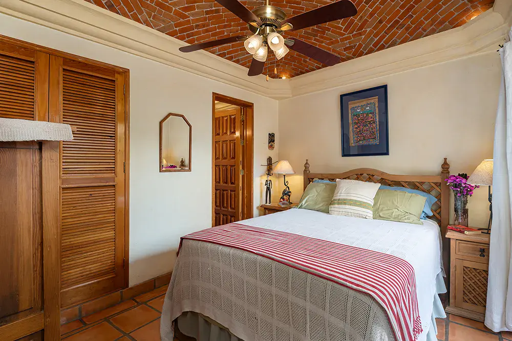 Casa DeeDee, bedroom with a brick vaulted ceiling and a red striped blanket, San Miguel de Allende